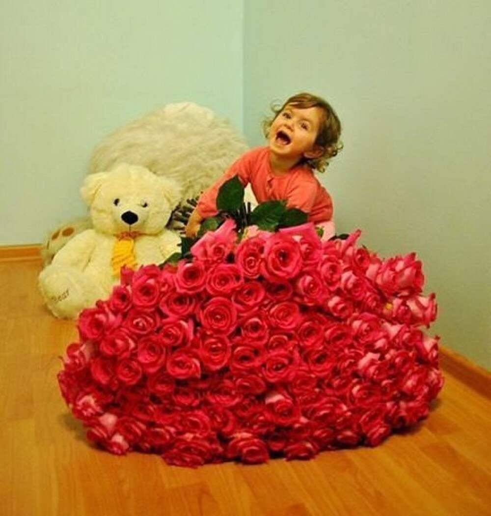 Ребенок с большим букетом роз
