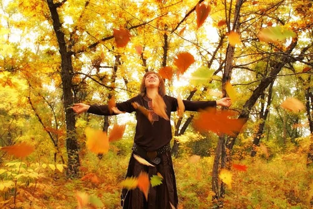 Ветер играет легкой листвою. Листопад и женщина. Осенние листья кружатся. Осень листопад женщина. Девочка кружится в осенней листве.