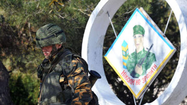 Российский военный на фоне плаката «Никогда не предавать» в Евпатории