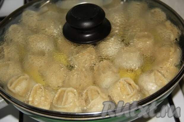 Накрыть сковороду крышкой. Когда вода (или бульон) закипит, убавить огонь до минимума и готовить блюдо 45 минут. За это время и картошка, и курица, и манты будут полностью готовы. 
