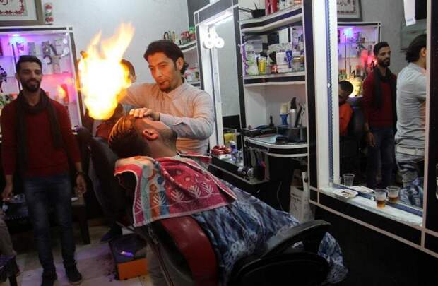 Палестинский парикмахер делает укладку огнём