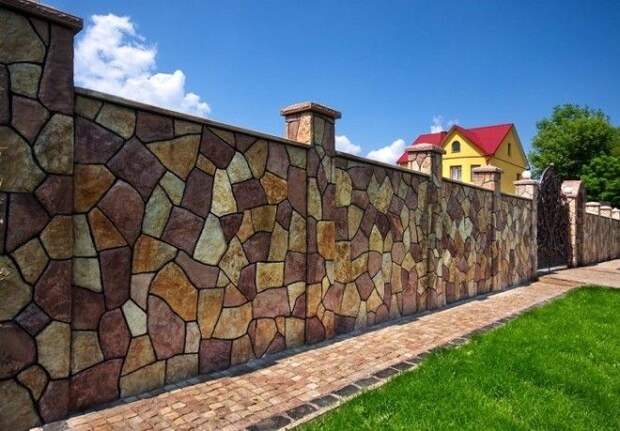 С виду забор из разных цветных камней но нет Это просто на бетоне сделали дизайн дикого разноцветного камня различных размеров