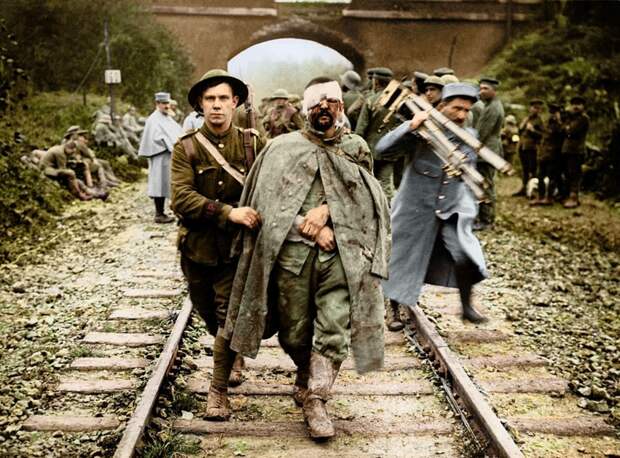 Британский солдат помогает раненому немецкому заключенному, 1916 г. архивное фото, колоризация, колоризация фотографий, колоризированные снимки, первая мировая, первая мировая война, фото войны