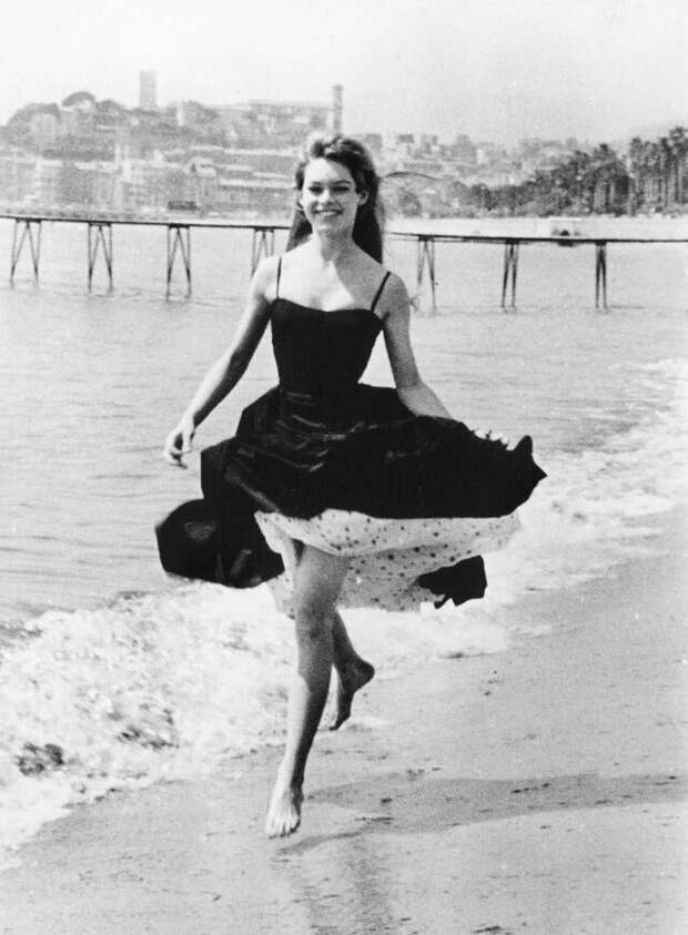 Брижит Бардо прогуливается по пляжу во время Каннского кинофестиваля, апрель 1956 года звезды, знаменитости, лето, пляж, прошлое, ретро, фотография
