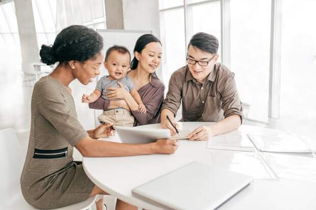 Professional woman reviews paperwork with young family.