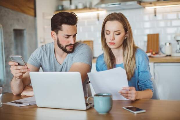 Young couple looking over finances in the kitchen. 