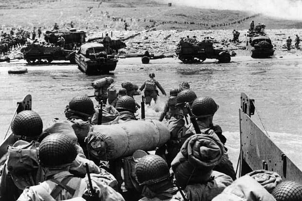 Troops Landing 7th June 1944: American assault troops and equipment landing on Omaha beach on the Northern coast of France, the smoke in the background is from naval gunfire supporting the attack. (Photo by Fox Photos/Hulton Archive/Getty Images)