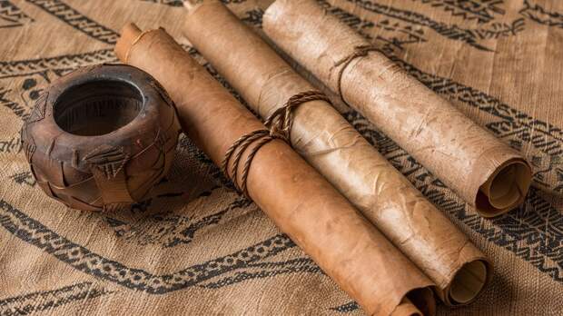 Древние папирусы свернуты на столе Древние папирусы свернуты на столе