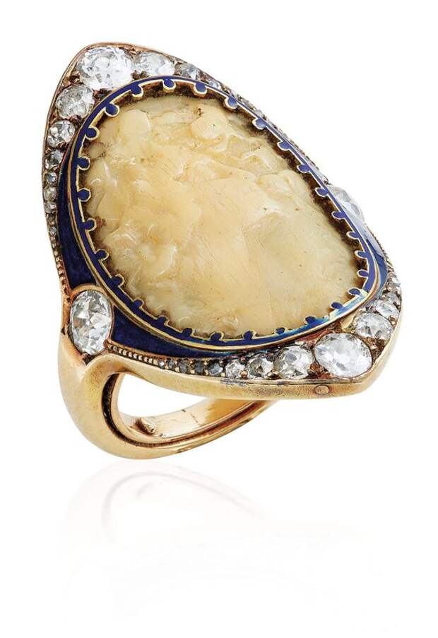 AN ART NOUVEAU GALALITH, DIAMOND AND ENAMEL RING, BY RENÉ LALIQUE. Set with a galalith curved plaque sculpted with the profile of a woman, within a blue enamel surround, applied with old-cut diamonds, circa 1895, ring size 6, monted in gold. Signed Lalique, with maker's mark for René Lalique. #RenéLalique #ArtNouveau #Jewelry #Jewellery #BijouxArtNouveau