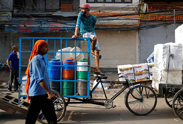 Рикша на городском рынке после смягчения локдауна в Дели