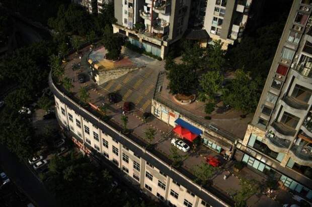 На верхнем этаже необычного дома в Чунцине есть стоянка для машин и даже нанесена дорожная разметка. | Фото: facebook.com.