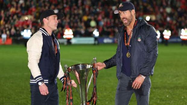 ryan reynolds and Rob McElhenney holding national league trophy