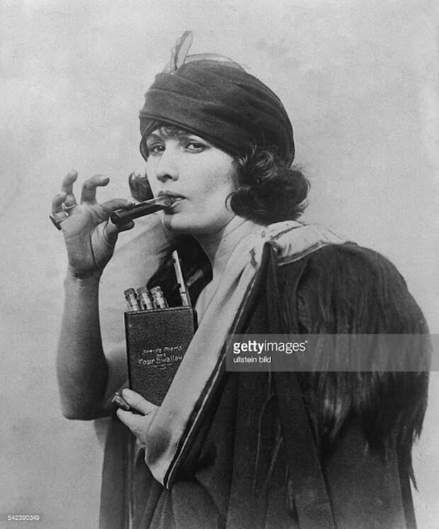 Женщина использует карманную книгу с надписью *Четыре глотка*, чтобы прятать в ней алкоголь во время сухого закона. 1920-е гг. 