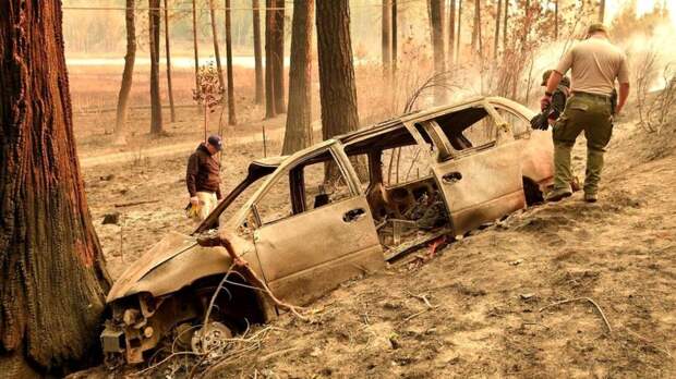 Помощники окружного шерифа обследуют сгоревший автомобиль - порой огонь распространяется так быстро, что люди не успевают эвакуировать свои машины
