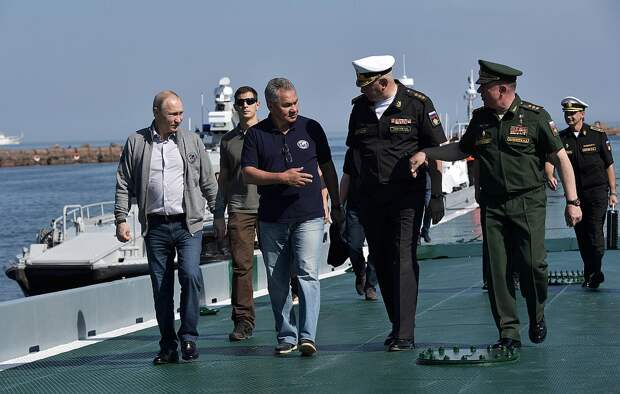 Путин в сопровождении министра обороны Сергея Шойгу прибыл на катере к плавучему причалу Фото: REUTERS