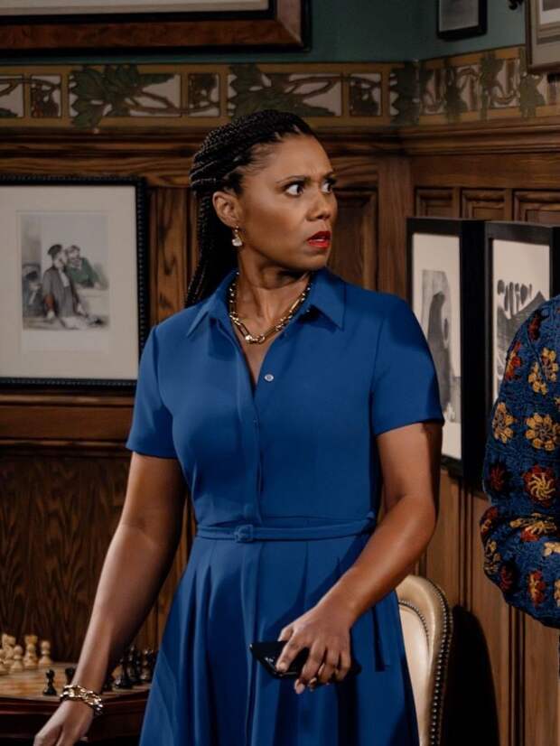 Olivia wears a blue shirt dress and looks startled