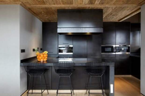 Эффектный черный кухонный контем с теплым деревянным полом и нарочито грубым неотесанным потолком