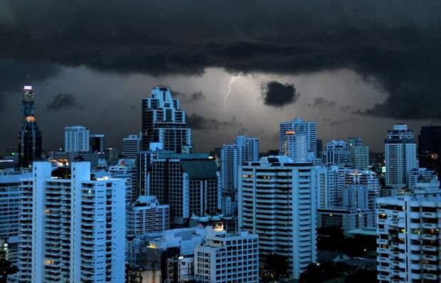Молния освещает небо и здания в Бангкоке