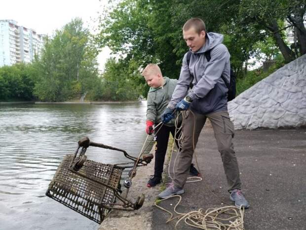 Денис Щелкушин с младшим братом вытаскивают из воды тележку/Из личного архива