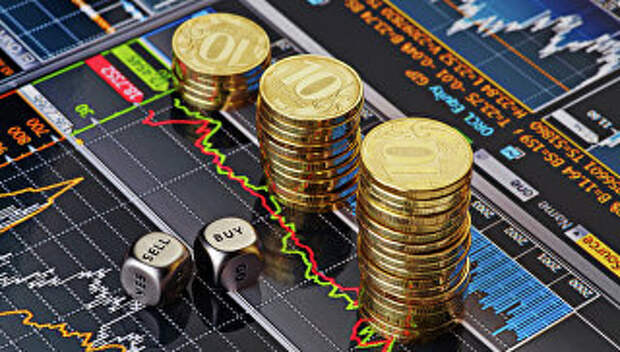 Стопки десятирублевых монет на экране с биржевыми графиками. Архивное фото