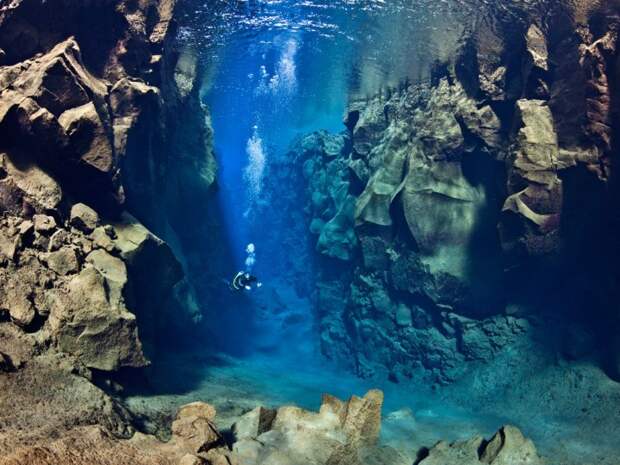 Аквалангист проплывает между тектоническими плитами в Исландии