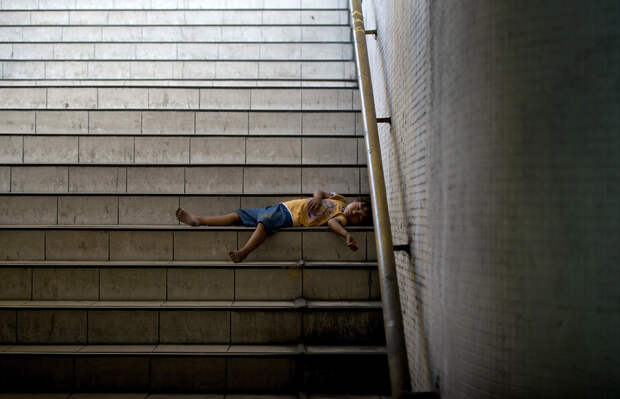 Ребенок спит на ступеньках подземного перехода в Маниле, Филиппины
