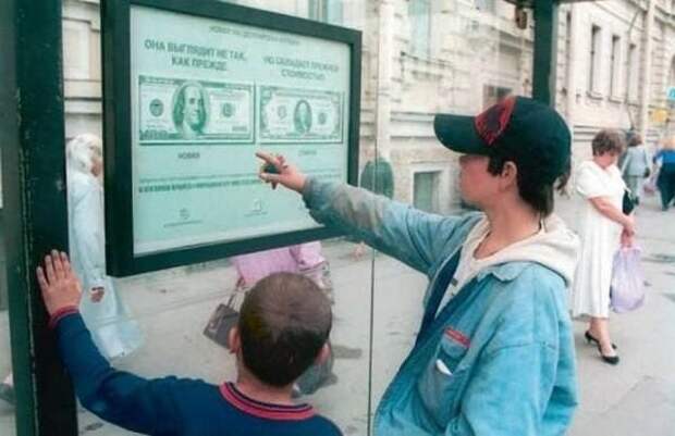 Дети рассматривают памятку о новом дизайне 100–долларовой банкноты, размещённую на автобусной остановке, 1996 год, Москва