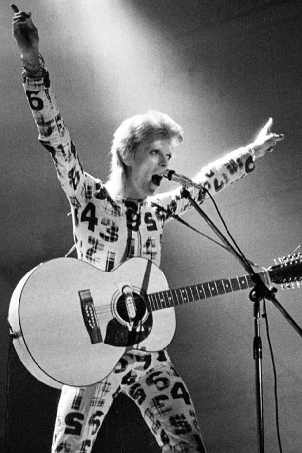 Британский рок-певец в комбинезоне с принтом во время живого выступления в рамках первого этапа турне «Ziggy Stardust Tour».