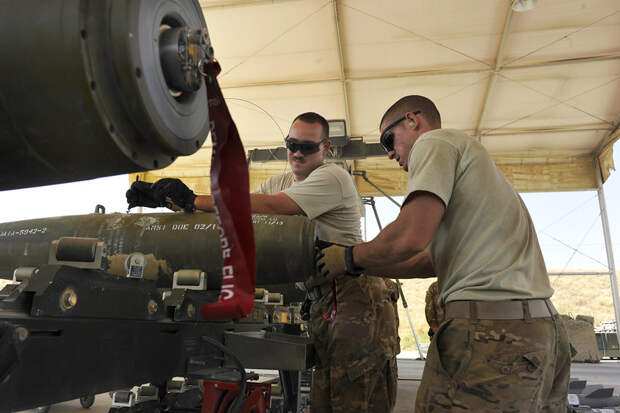 BAGRAM AIRFIELD, Afghanistan -- U.S. Air Force Senior Airman Christopher Reed (left) and Airman 1st Class Mark Mayeaux, munitions systems Airmen with the 455th Expeditionary Maintenance Squadron, install the power cable that connects the initiator to the