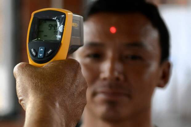 A Nepalese health worker inspected an arriving passenger with an infrared thermometer for signs of fever, one of the symptoms of Ebola, at a health desk at the international airport in Katmandu, Nepal on Aug. 20.