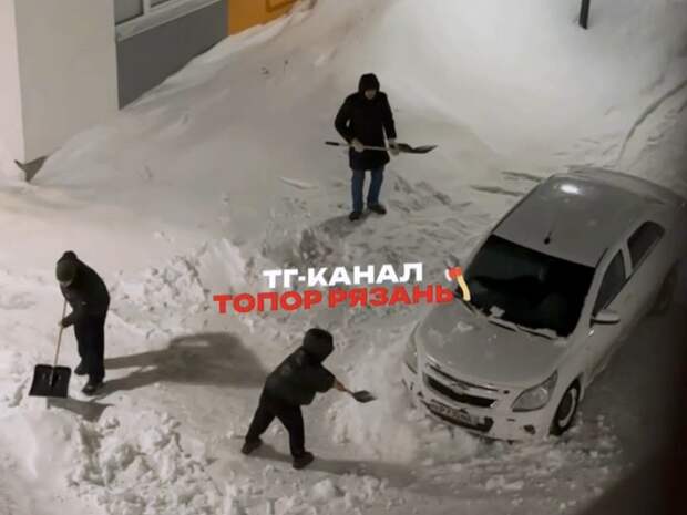 В Рыбном трое мужчин засыпали снегом стоящий на тротуаре автомобиль
