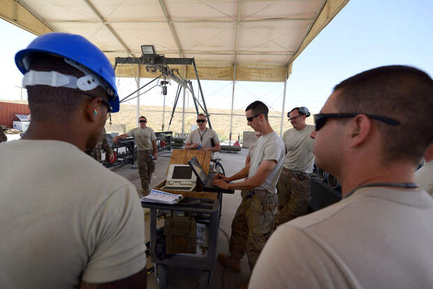 U.S. Air Force Airmen assigned to the 455th Expeditionary Maintenance Squadron gather together to review safety procedures before building 10 GBU-38 bombs at Bagram Airfield, Afghanistan Aug. 26, 2014. The GBU-38 is an essential part of the weapons system
